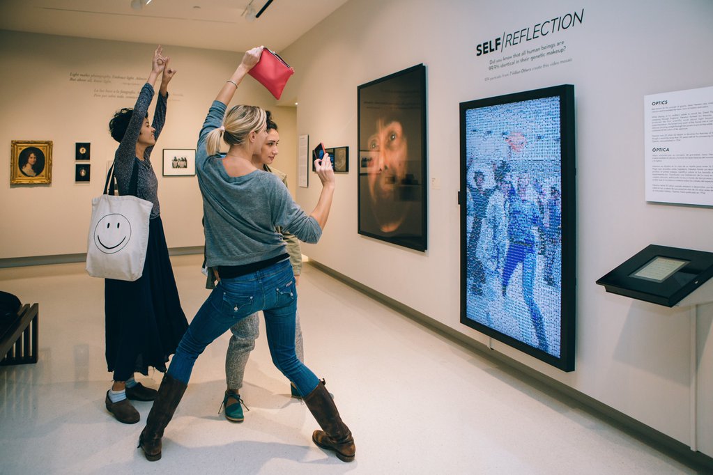 Visitors interacting with the  screen in the gallery